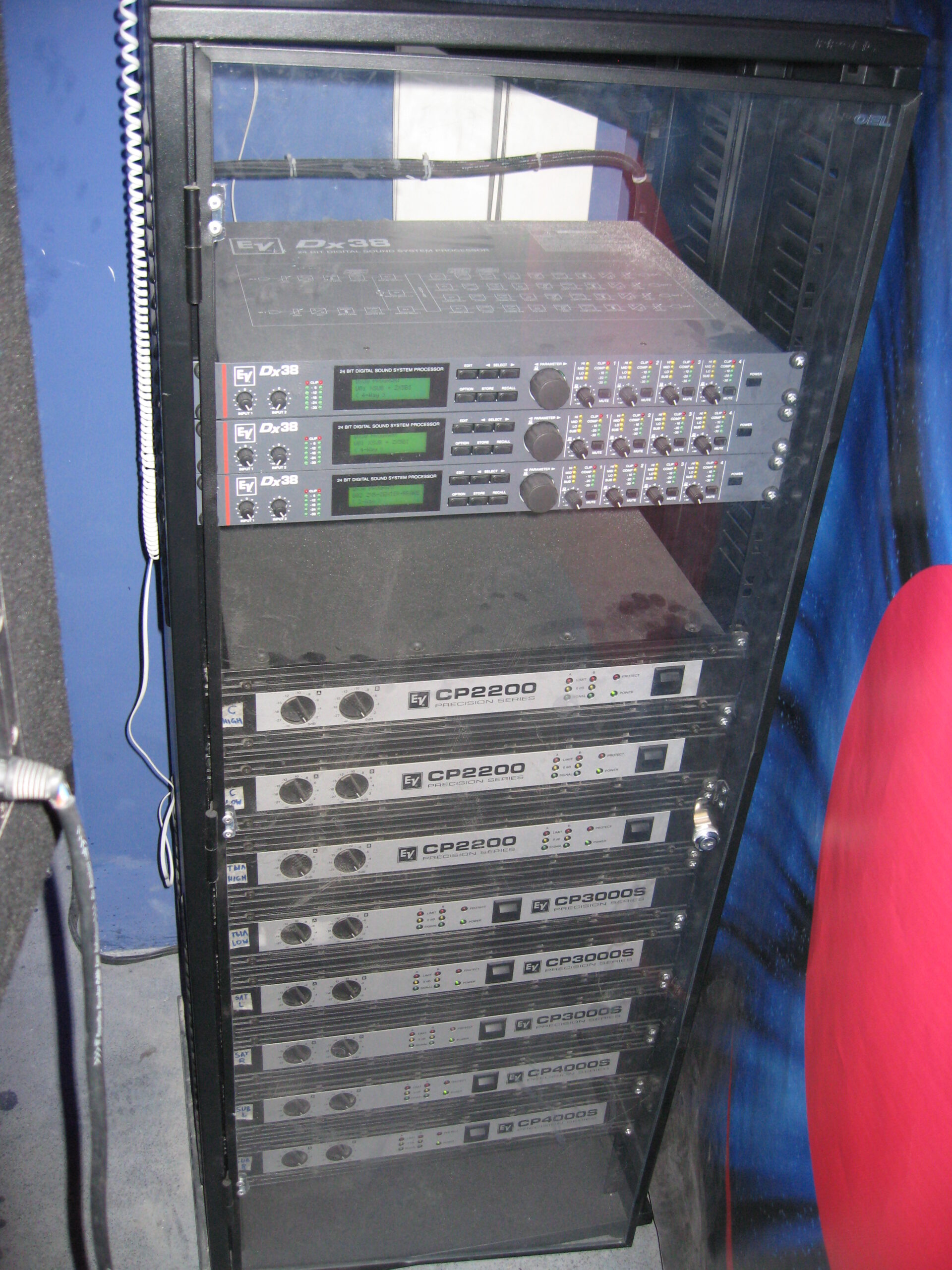 Vorderseite des Racks einer Clubbeschallungsanlage: drei digitale Prozessoren und acht Endstufen mit den Kanalbeschriftungen SUB L/R und SAT L/R